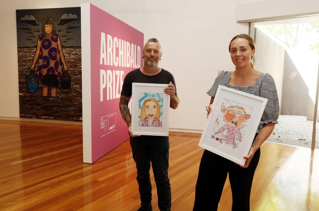 Gallery officer Tayla Martin and curator Andrew Halyday holding some of the local Young Archie prize finalists. Picture by Les Smith 