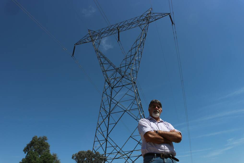Gregadoo's David Falepau under an existing 35-metre, 330kV tower on his property. He says he wasn't consulted about EnergyConnect. Picture by Andrew Mangelsdorf