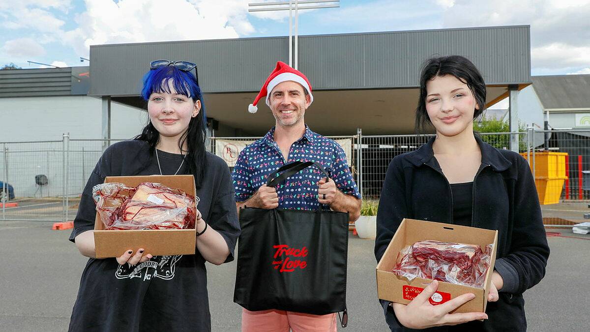 Together Church pastor Bobby Gardner with Raynah Northey and Ziya Northey giving away free family roasts for Christmas. Picture by Les Smith