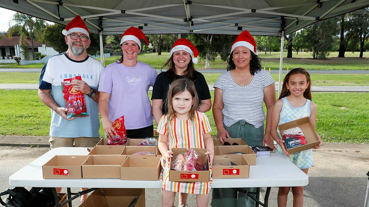 5-year-old Tori McMartin with (L) Alan Crozier, Together Church pastor Mel McMartin, pastor Hannah Wilson, Nicola Gardner and 9-year-old Ava Gardner give away free family roasts on Thursday afternoon. Picture by Les Smith