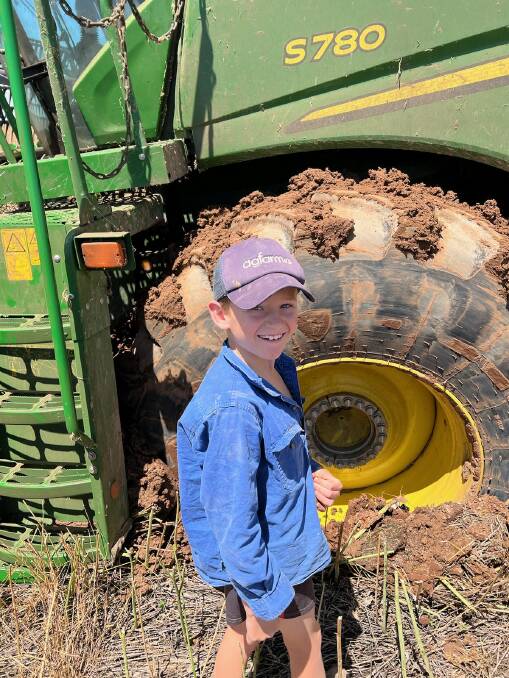Junior farmer Tom Lane inspects a bogged header during harvest. Picture supplied.