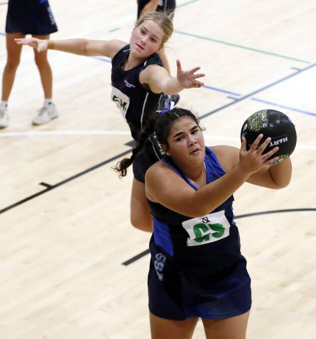 Southern Sports Academy's Kaelani Goolagong grabs a pass while she is defended by Hunter Academy of Sport's Emmy Jensen. Picture by Les Smith