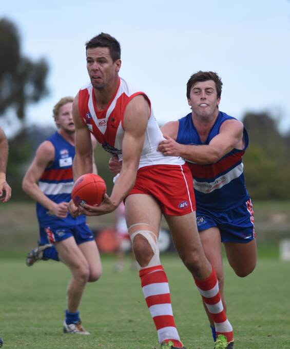 QUICK HANDS: Griffith ruckman Michael Griffiths gets a handball away despite pressure from Turvey Park opponent Jack Brooks at Maher Oval on Saturday. Picture: Laura Hardwick