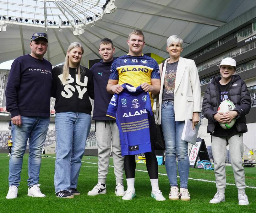Charlie Guymer shows off his Parramatta jumper at CommBank Stadium on Wednesday, flanked by his family, father Dean, sister Lily, 17, brother Lenny, 14, mother Rachael and brother Joey, 11. Picture supplied
