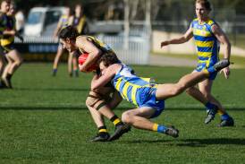 Lachie Johnson tries to bring down Will Kirkup as Mangoplah-Cookardinia United-Eastlakes downed Wagga Tigers at Robertson Oval on Saturday. Picture by Tom Dennis