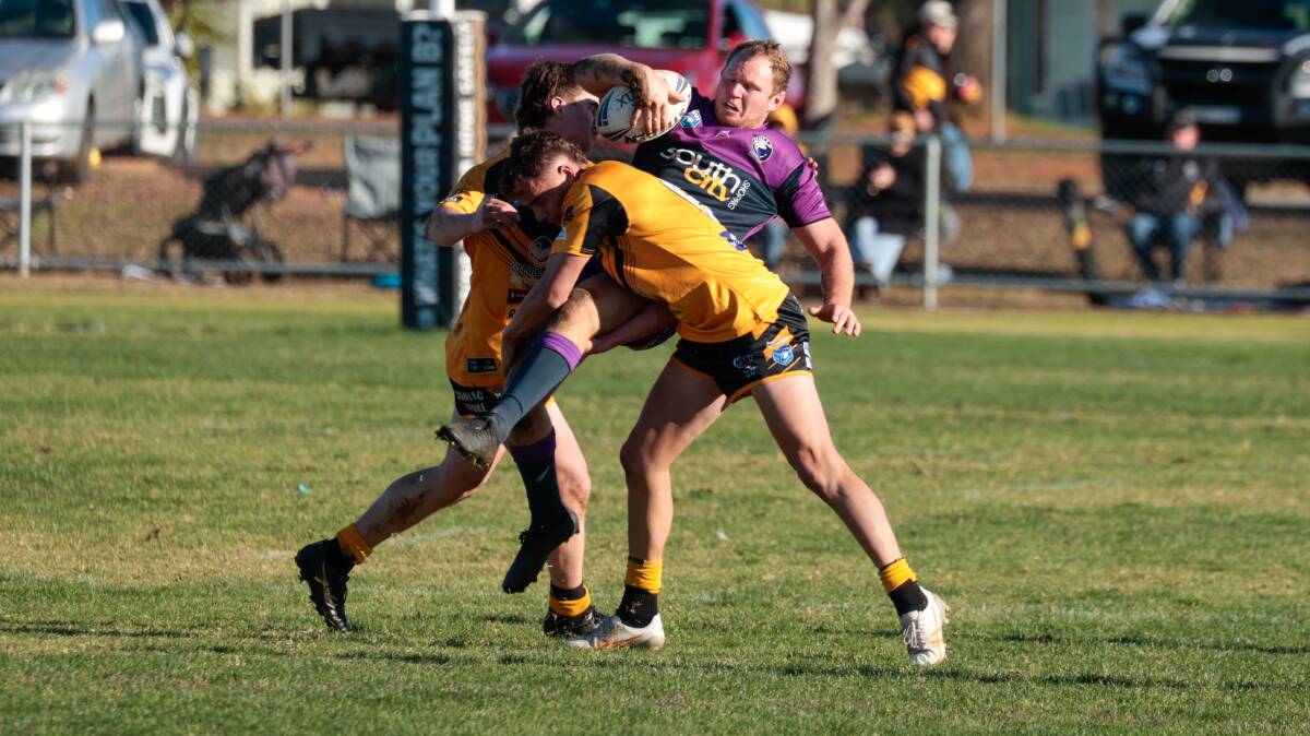 Tim Hurst is lifted up by the Gundagai defence in Southcity's win at Harris Park on Sunday. Picture by Bernard Humphreys