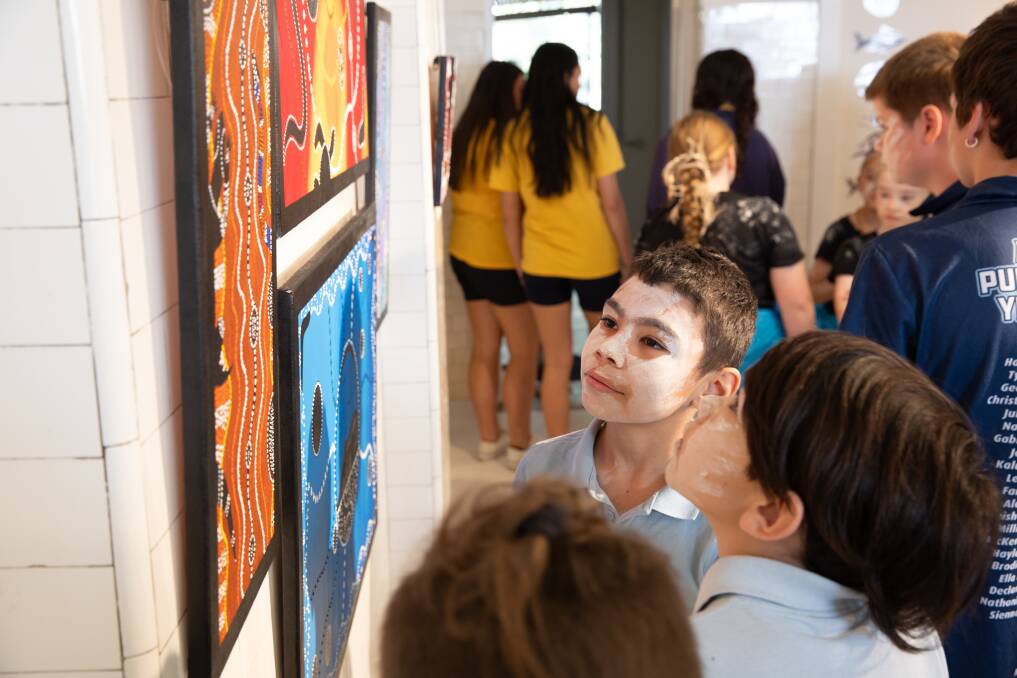 Year three student Corey Hughes, nine, admires the art of his peers after performing a traditional dance with Ashmont Public School's Waganha Bila-dha group at The First Nations Community of Schools Art exhibition at The Ambo Gallery. Picture by Madeline Begley