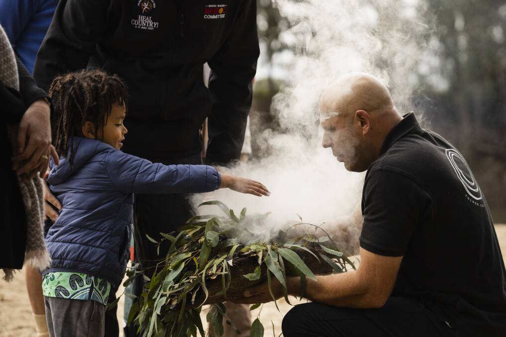 Kian McKenzie, 4, participates in a smoking ceremony conducted by Wiradjuri man Luke Wighton at Wagga Beach during Reconciliation Week 2023. Picture by Ash Smith 