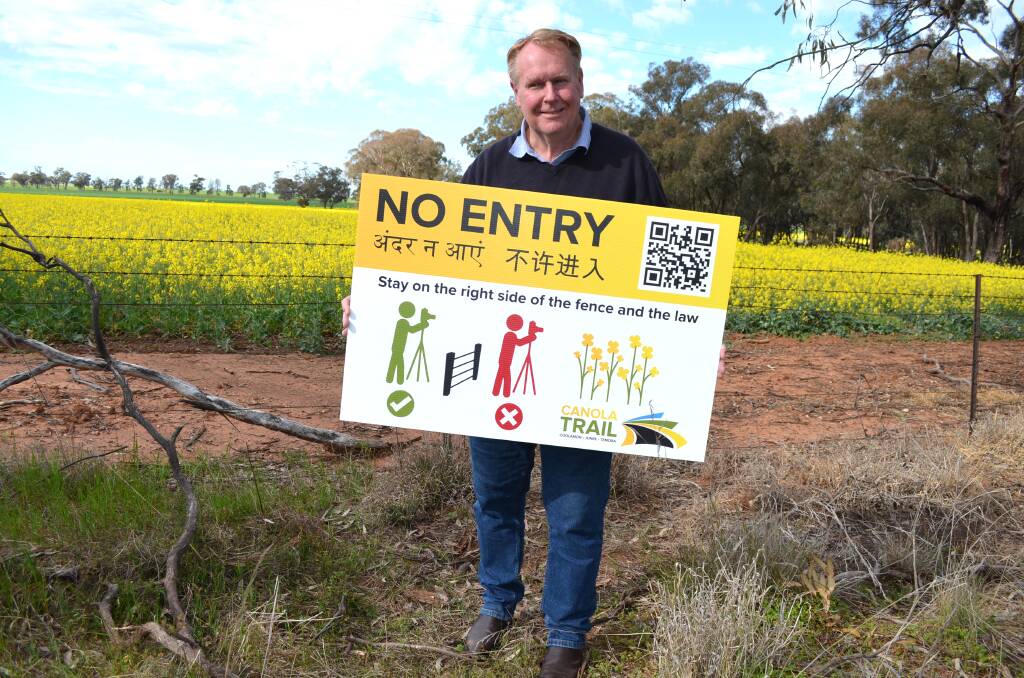 Coolamon mayor David McCann with one of the signs warning people to stay off private properties and out of blooming canola crops. Picture by Taylor Dodge