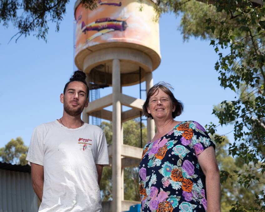 Mural artist Damien Mitchell with Uranquinty Progress Association president Deb Bewick at the town's water tower. Picture by Madeline Begley 