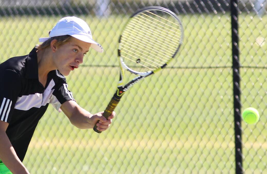 SHOT: Jonathon Male, 14, watches his handiwork at the junior tennis in Wagga on Saturday. Picture: Les Smith