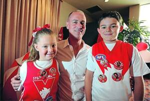 HAPPY RETURN: Sydney Swans legend Dennis Carroll was special guest at the Sydney Swans Supporters of Wagga Christmas Party at the Rules Club in Wagga yesterday. Carroll met young Swans fans Takeiah Maxwell, 6, and Caden Maxwell, 10, at the function. Picture: Addison Hamilton