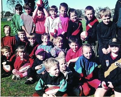 THEN: Brent Carroll, Brad Langtry, Ben Carroll, (third, fourth and sixth from left, back row), Jeremy Graetz, Daniel Fox, Kerrod Roberts  (first, second and third from left in second row) and Bryce Graetz (middle front behind boy with football) at Marrar Auskick almost 20 years ago.