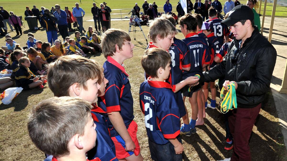 Daniel Mortimer hands out medals to Henschke players after their Mortimer Shield win this week. Picture: Les Smith